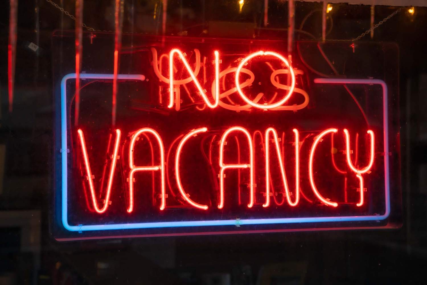 Closeup of the lighted signage saying "NO VACANCY" on the glass